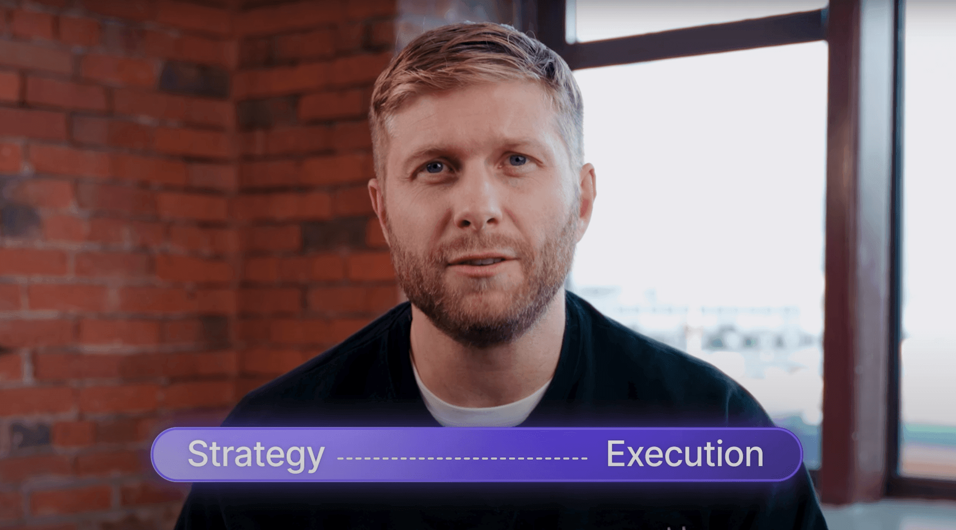 Man in front of brick wall with text 'Strategy ------------------ Execution' below.